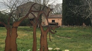 A sculpture of a tree with a rusted trunk and branches in a grassy area with a building in the background. - Apartment in Farmhouse for Families with Pool (Porchiano del Monte - Amelia)