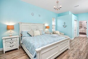 A bedroom with a bed, nightstands, and a chandelier.