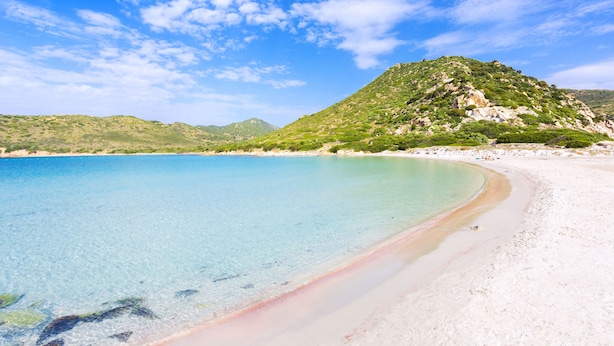 A beach with clear turquoise water, white sand, and green hills in the background. - One bedroom apartment premium (4 people) - Residence Le Fontane (Villasimius)