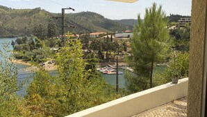 A balcony with a view of a lake, boats, and buildings in the background. - House in Castelo de Bode, blue lake (Castelo de Bode)