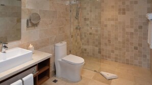 Une salle de bain moderne dotée d’un grand lavabo, de toilettes et d’un espace douche.