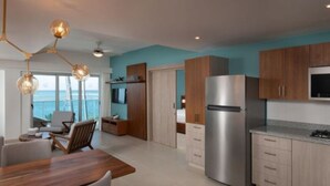 Une cuisine moderne dotée d’appareils électroménagers en acier inoxydable, de meubles en bois et d’un coin repas offrant une vue sur l’océan.