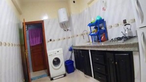 Cocina compacta con lavadora, lavaplatos y estufa.