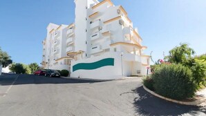 Un hotel de varios pisos con fachada blanca y detalles verdes en la parte inferior.