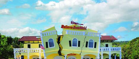 A yellow building with a sign that reads 'Believe It or Not!' and a cracked facade.