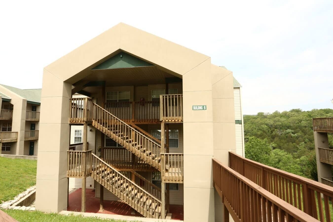 A multi-story building with a central staircase, balconies, and a sign indicating 'Building 6'.