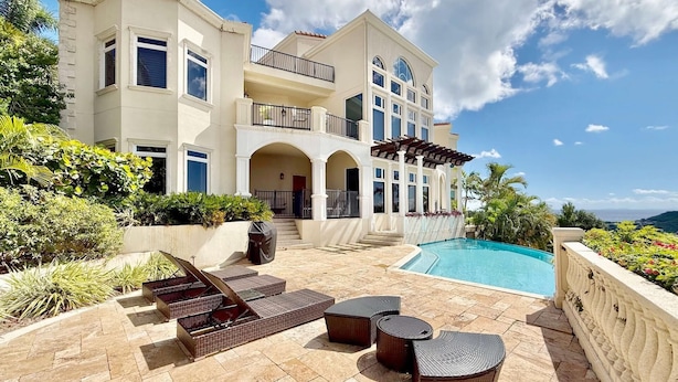 A large, two-story house with a swimming pool, outdoor seating, and a view of the ocean. - Frangipani Private Pool and Tesla Backup! (St. John)