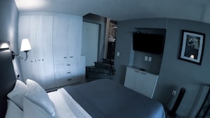 Un dormitorio con cama, armario, escritorio y televisor.