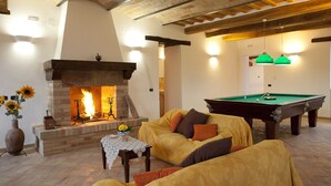 A cozy living room with a fireplace, a pool table, and comfortable seating. - Villa Serena - Homelike Villas (Sant'Angelo in Pontano)