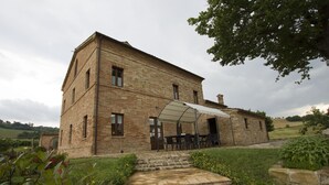 A two-story stone building with a covered patio area. - Villa Serena - Homelike Villas (Sant'Angelo in Pontano)