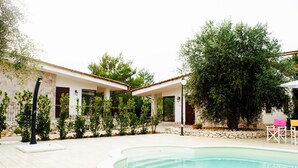 A modern house with a swimming pool, surrounded by greenery and a stone wall. - TENUTA LE CRIE, VILLETTA RESIDENCE with swimming pool and tennis court (Muro Leccese)