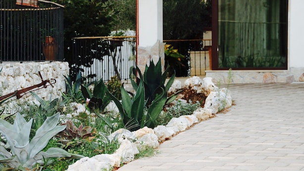 A paved pathway leading to a building with a stone wall and various plants. - TENUTA LE CRIE, VILLETTA RESIDENCE with swimming pool and tennis court (Muro Leccese)