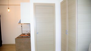 A room with a kitchenette, a closed door, and a wardrobe. - The sunny House "In the center"  (Catania)