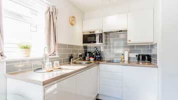 Apartamento Premier, 1 cama de matrimonio grande con sofá cama, cocina básica, planta baja | Cocina privada | Frigorífico, microondas, placa de cocina y máquina de café espresso