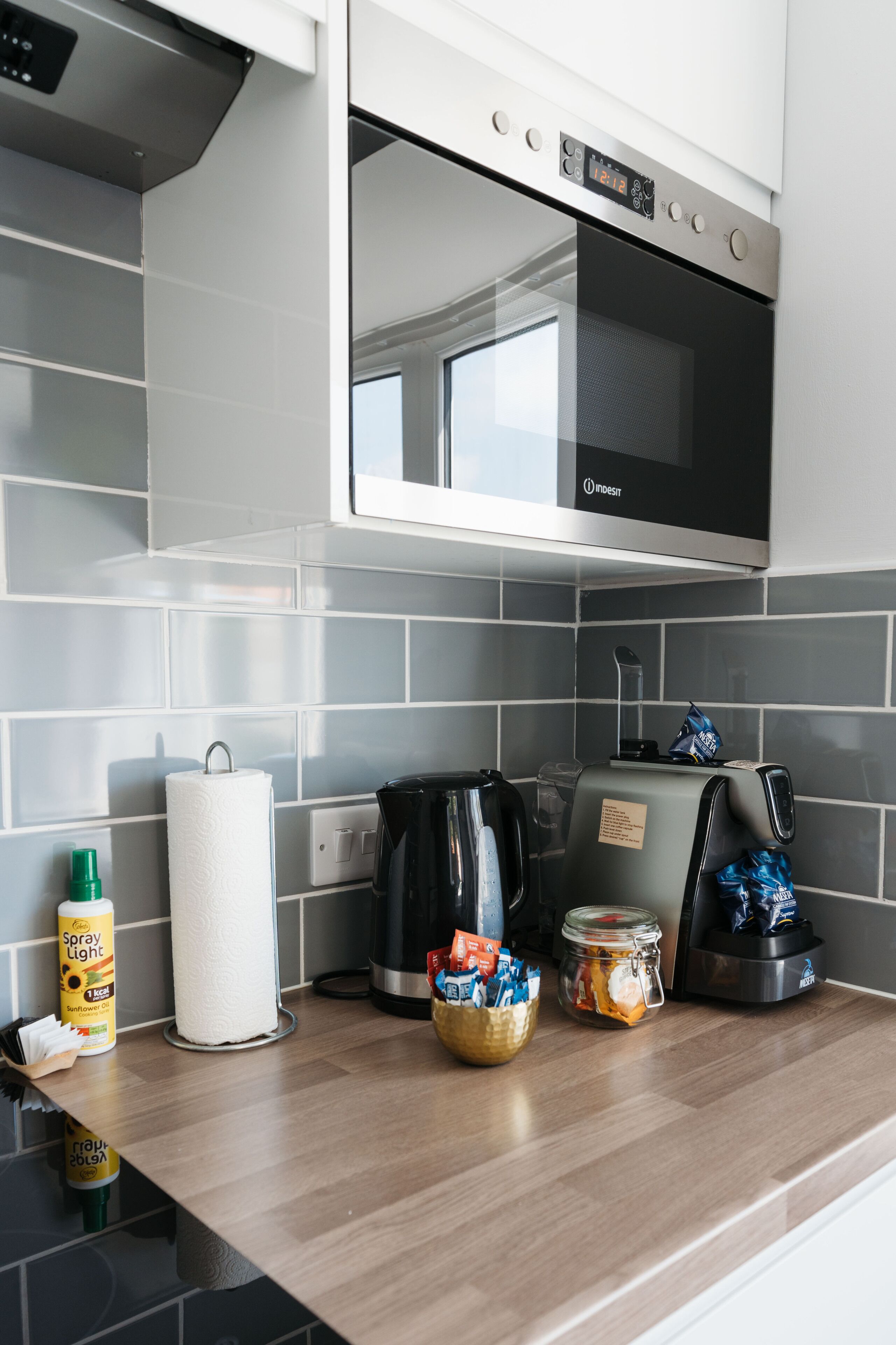 A kitchen with a modern oven, a coffee maker, and various food items on the counter.