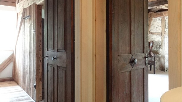 A wooden door leading to a room with a tiled floor and a visible shower area. - Lichtblick apartment near Bad Windsheim, fireplace, garden, barbecue, panorama screen, massage (Ickelheim)