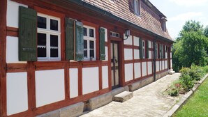A traditional half-timbered building with a stone pathway leading to the entrance. - Lichtblick apartment near Bad Windsheim, fireplace, garden, barbecue, panorama screen, massage (Ickelheim)