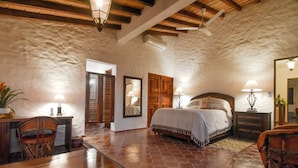 A bedroom with a wooden bed, a desk, and a chair. There are two lamps and a mirror on the wall. - Private villa- 3 bdrm & 4 bath with ocean views and new private infinity pool  (Puerto Vallarta)