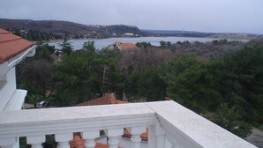 Un balcón con vistas a un lago y colinas.