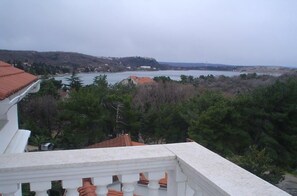 A balcony with a view of a lake and hills.