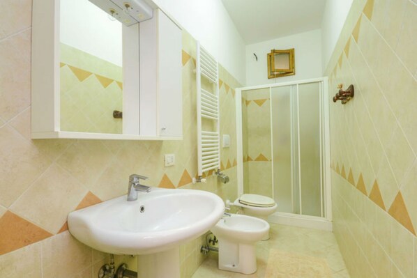 Un baño con lavabo, inodoro y ducha.