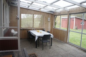 Enjoy dining al fresco on the covered patio with a table set for a meal.