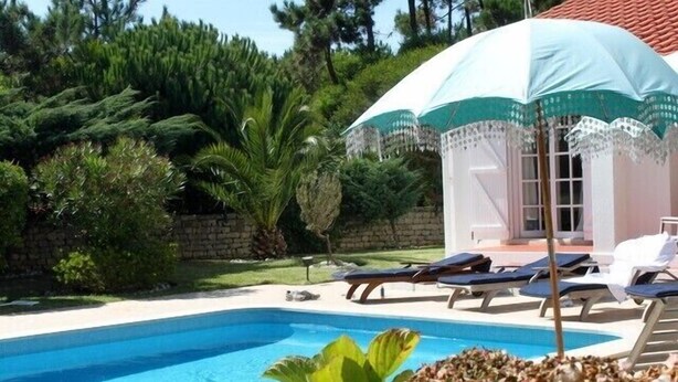 A swimming pool with lounge chairs and a covered area with a white and green umbrella. - Villa with Books, Sun, Swing Bed, Private Pool And A Spacious Garden To Enjoy (Unknown)