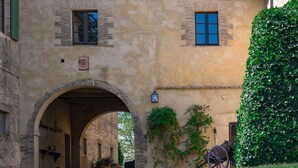 A historic building with an arched entrance, a clock, and a carriage. - The Real Tuscany great for families and friends. (Buonconvento, Siena)