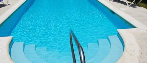 Una piscina al aire libre, una piscina climatizada