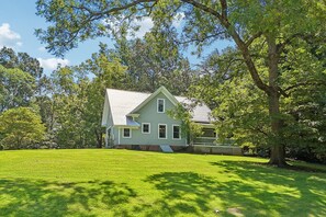 A two-story house with a front porch and a well-maintained lawn.