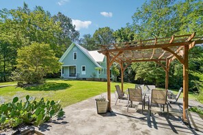 A house with a covered patio area featuring outdoor furniture.