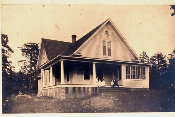 A two-story house with a porch and a chimney.
