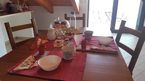 Una tavola imbandita con diversi piatti, tra cui una ciotola di frutta, una brocca e un barattolo di vetro.