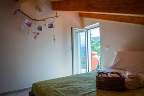 Un dormitorio con una cama, una cesta de mimbre y vistas al exterior.