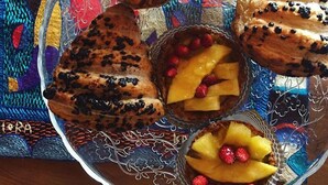 Un piatto con una varietà di pasticcini e dolci su una tovaglia fantasia.