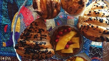 Un piatto con una varietà di pasticcini e dolci su una tovaglia fantasia.