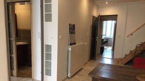 A hallway with a wooden table, a radiator, and a staircase.