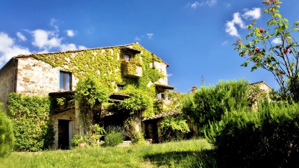 An old stone building with ivy-covered walls and a rustic appearance.