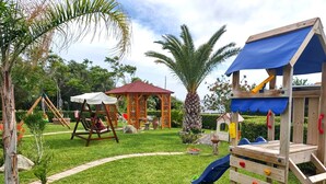 A playground with a swing set, slide, and climbing structure. - Deluxe three-room apartments - at Le Casette sul Mare (Capo Vaticano)