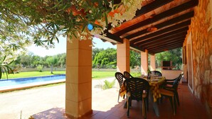 An outdoor patio with a pool, covered seating area, and a stone wall. - Can Toni, Wi-fi, Pool, Garden, 15 Minutes From the beach Es Trenc  (Mallorca)
