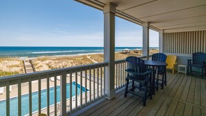 A covered deck with a pool, beach view, and outdoor seating. - SC303 Seaside Dream by First Flight Rentals (Kill Devil Hills)