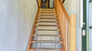 Eine Holztreppe mit Handlauf und einer Holztür am Fuß.