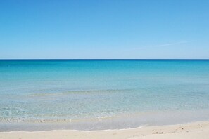 Una playa con agua turquesa cristalina y una orilla arenosa.