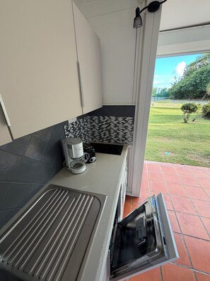 Uma cozinha com forno embutido, cafeteira e painel de azulejos.