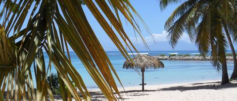 Ranta lähistöllä, aurinkotuoleja, rantapyyhkeitä