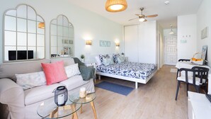 Un dormitorio moderno con cama, mesitas de noche y ventilador de techo.