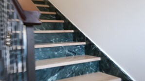Eine Treppe mit Holzboden und einer Marmorwand.