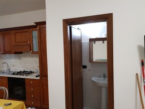 A kitchen with wooden cabinets, a gas stove, and a sink.