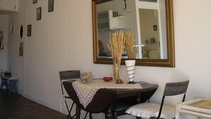 A dining area with a table, chairs, a large mirror, and wall-mounted pictures. - FESTIVAL SEA CLASS & CHARME CANNES MONTFLEURY (Cannes)