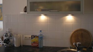 A kitchen with white tiles, a Quaker Oats cereal box, a water bottle, and a wooden barrel. - FESTIVAL SEA CLASS & CHARME CANNES MONTFLEURY (Cannes)